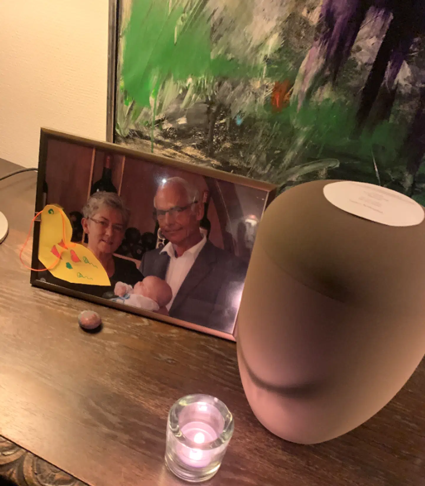 Her ses billede af Pia Elkjær Hansen sammen med sin nu døde ægtemand Poul Henning Hansen og deres ene barnebarn, da det blev døbt. Til højre ses urnen med asken fra Poul Henning Hansen. Den er nu begravet på kirkegård. Foto: Privat
