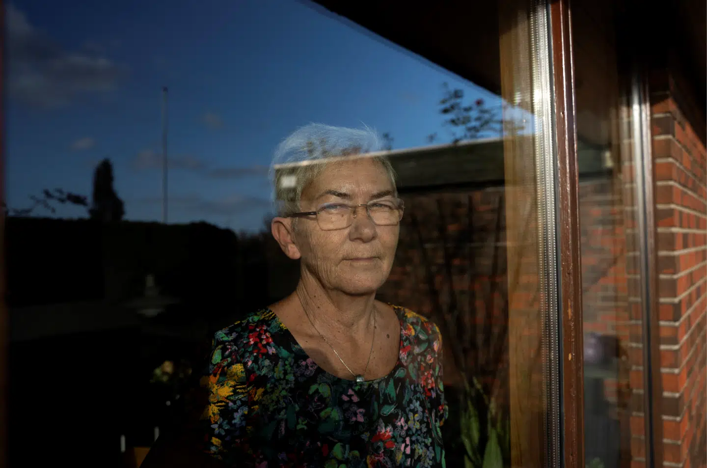 Enken Pia Elkjær Hansen kigger ud af vinduet i sit hus. Foto: Sarah Christine Nørgaard/Byrd