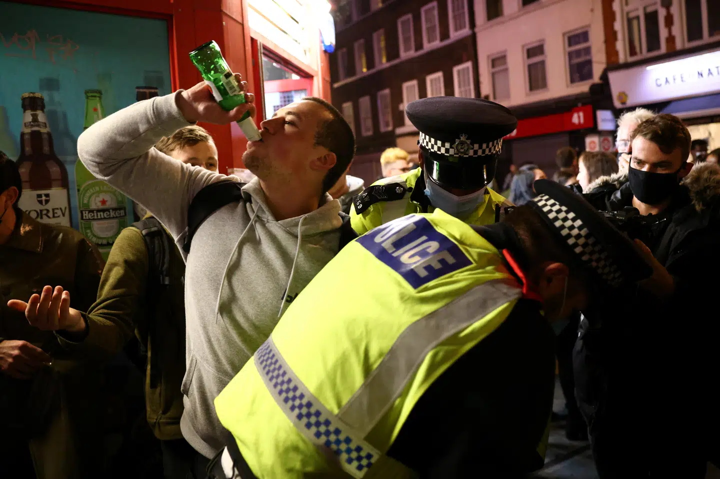 En mand i London drikker sin øl op, inden han bliver anholdt af politiet. Byens borgere flokkedes onsdag aften til pubber og restauranter i timerne op til en ny national nedlukning.