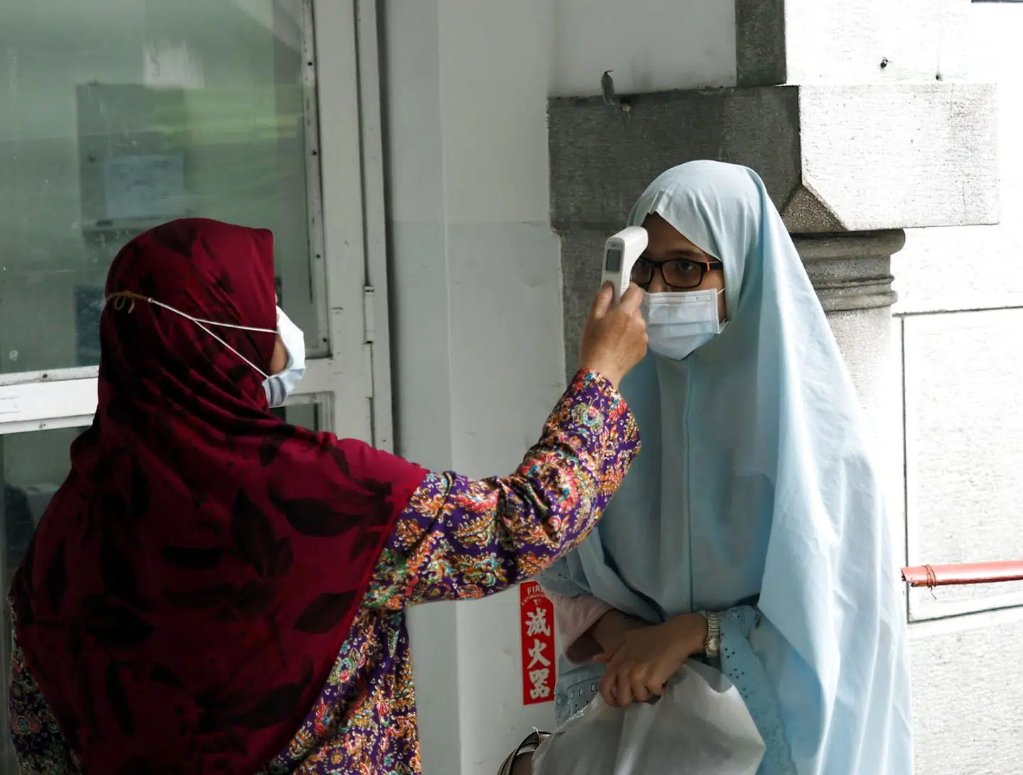 En muslimsk kvinde får målt sin temperatur forud for fredagsbønnen forleden i den store moske i Taiwans hovedstad Taipei.