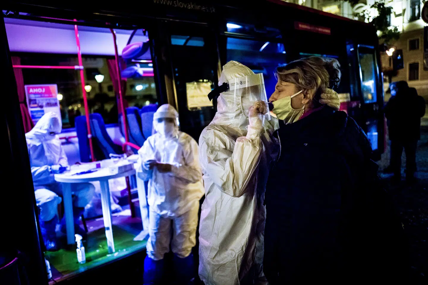En sundhedsmedarbejder i Slovakiets hovedstad, Bratislava, tester en kvinde for coronavirus lørdag aften. Kvinden var en af 3,6 millioner mennesker, der blev testet i løbet af weekenden. Vladimir Simicek/Ritzau Scanpix
