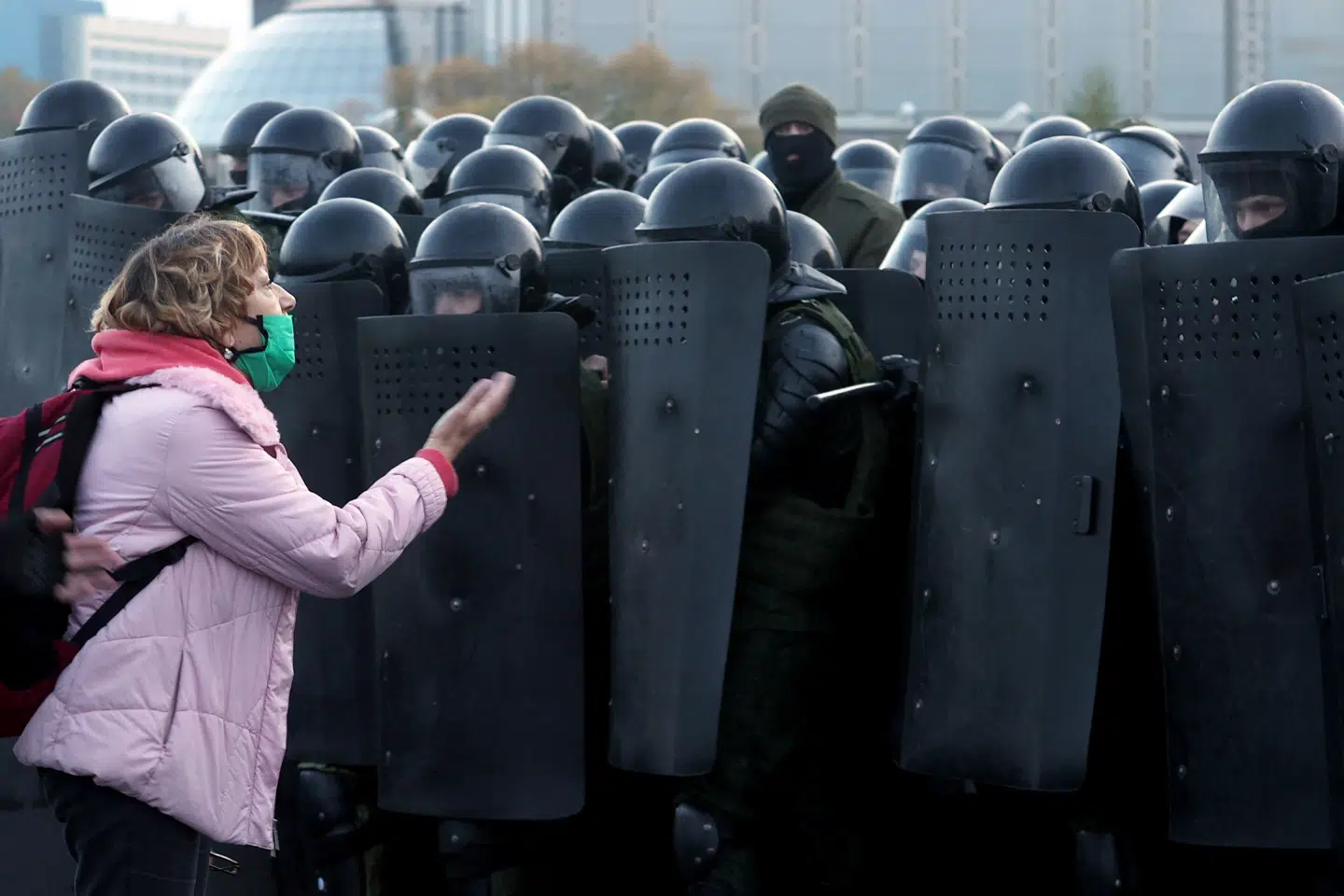 En kvinde diskuterer med betjente i kampudstyr, der søndag holder centrum af Minsk belejret under nye store protester mod regimet. Stringer/Ritzau Scanpix