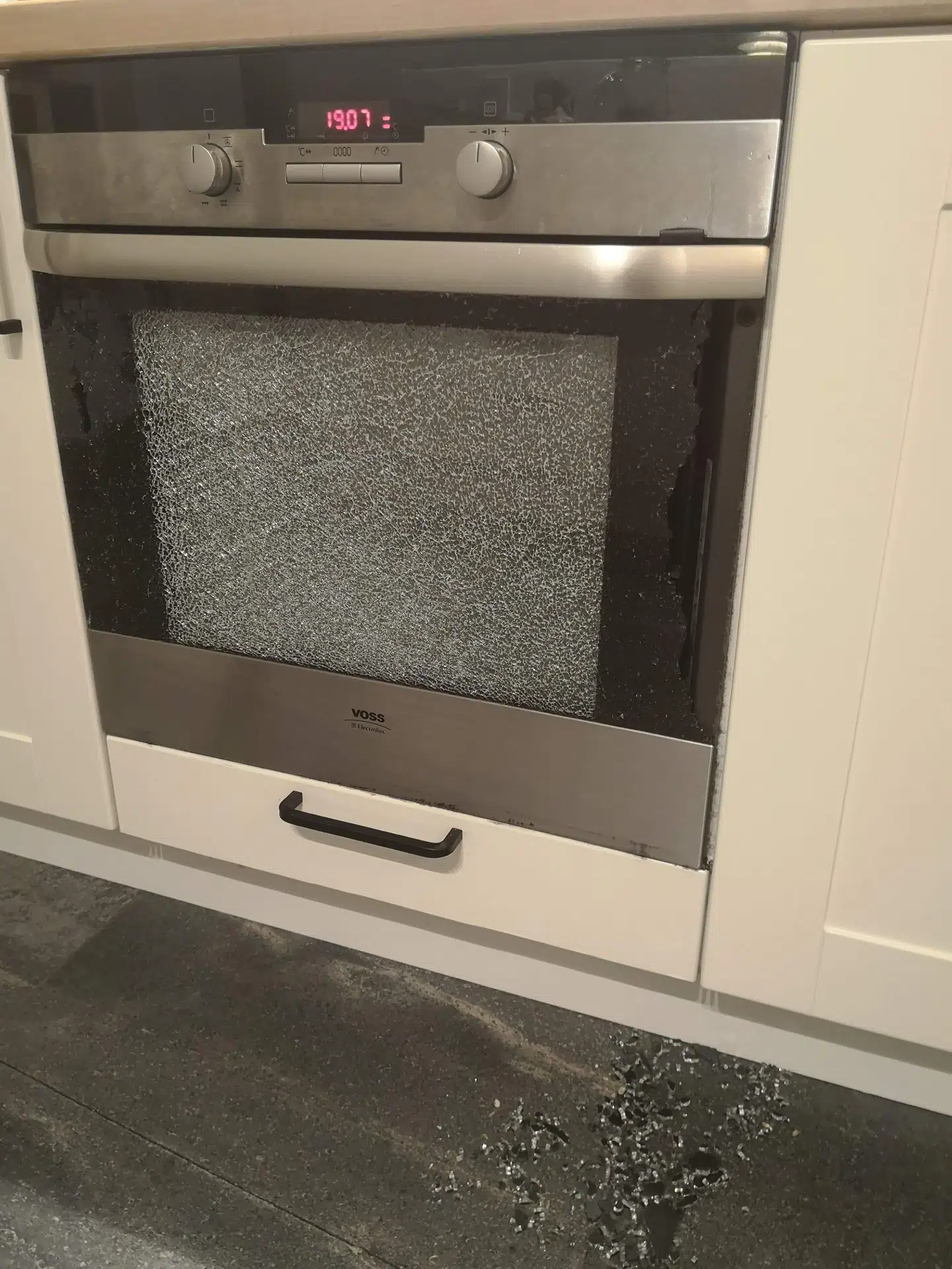 Ovnen efter eksplosionen. Lises mand har fejet skårene sammen i en bunke. Foto: Privat.