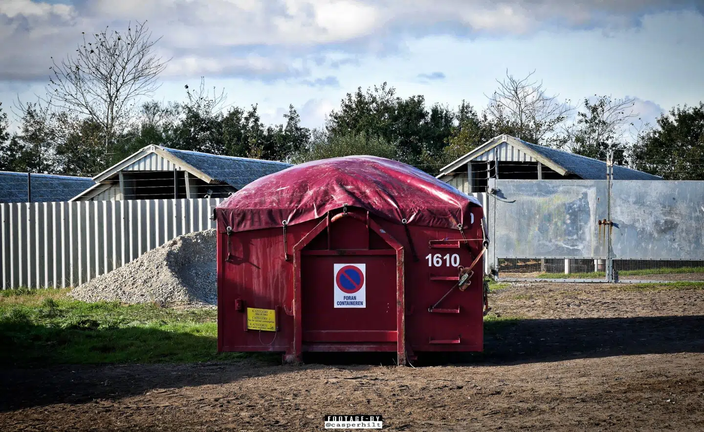 Her er en en container så overfyldt, at presenningen buler op.