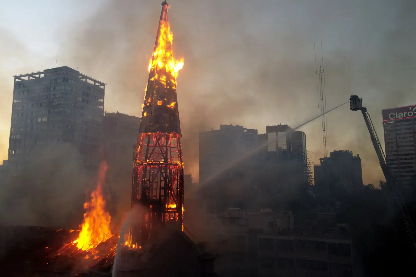 Maskerede personer satte ild til flere kirker i Chiles hovedstad, Santiago. Pablo Cozzaglio/Ritzau Scanpix