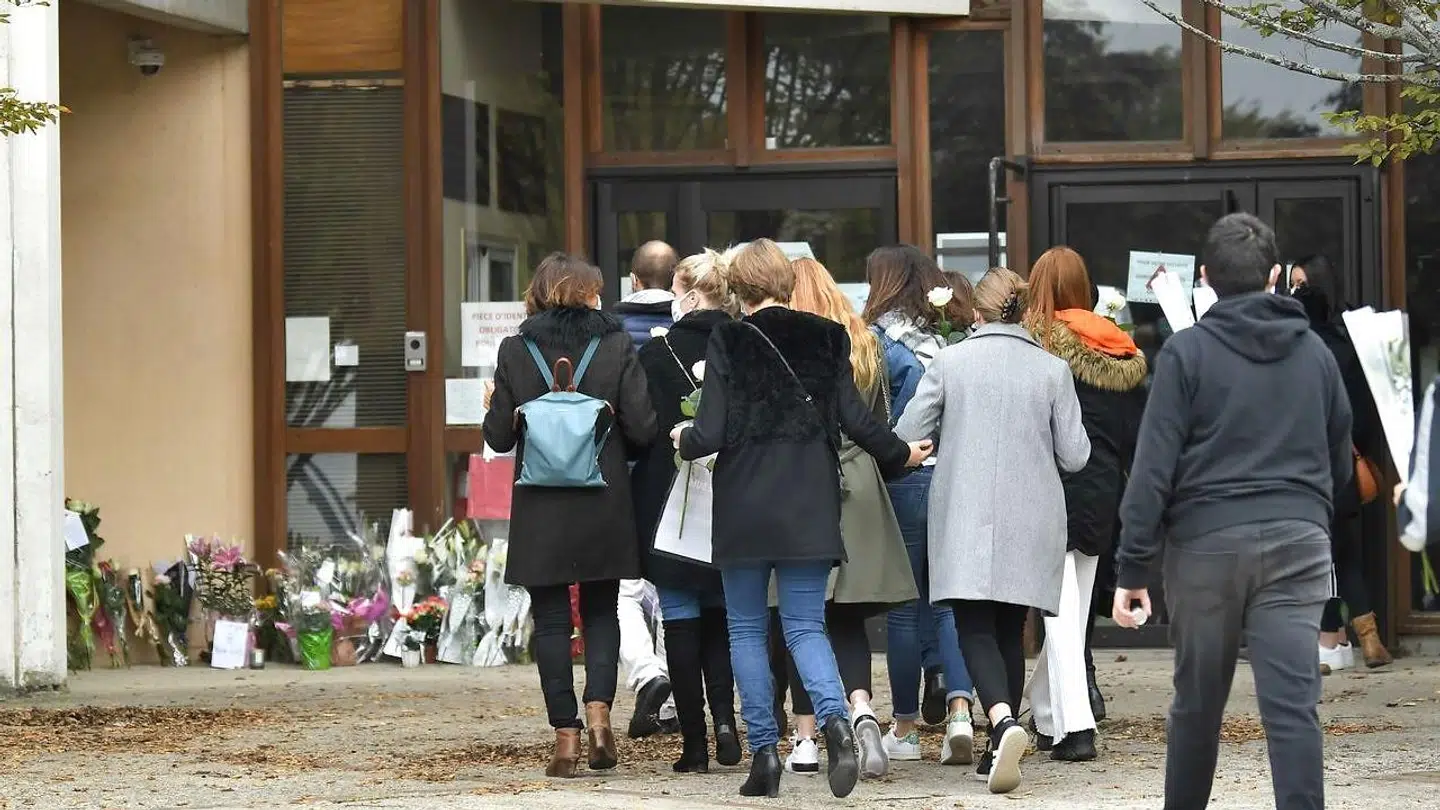 Et samfund i chok: Forældre og børn lægger blomster foran skolen i Conflans-Sainte-Honorine.