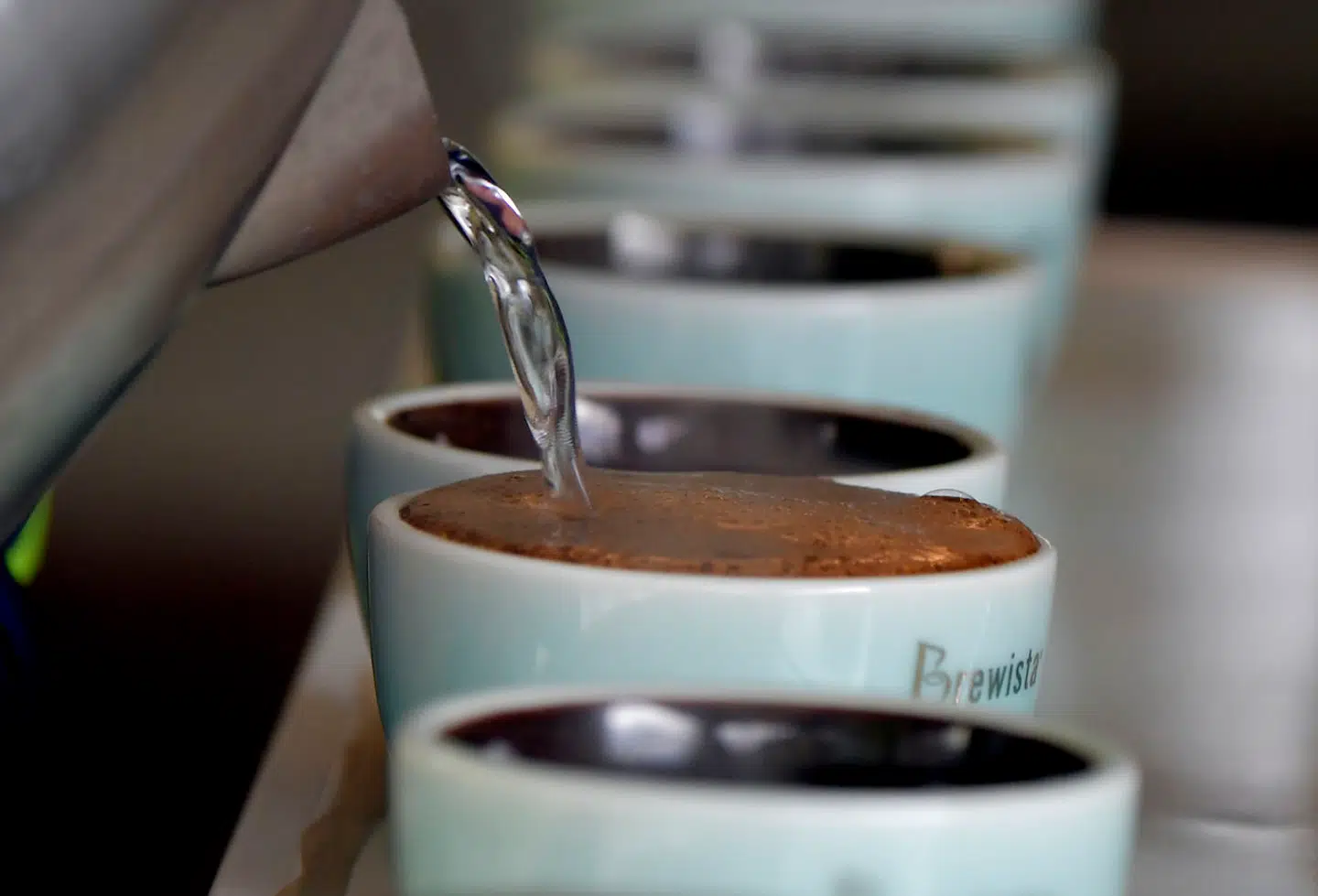 Kaffekopper gøres klar af en barista.