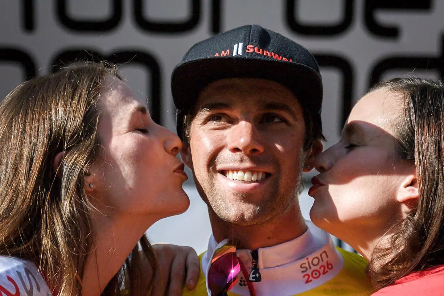 Australia's Michael Matthews of Team Sunweb (C) is kissed by hostesses after winning the prologue, a 4km race against the clock, Fribourg to Fribourg, at the Tour de Romandie UCI Pro cycling race in Fribourg on April 24, 2018 / AFP PHOTO / Fabrice COFFRINI