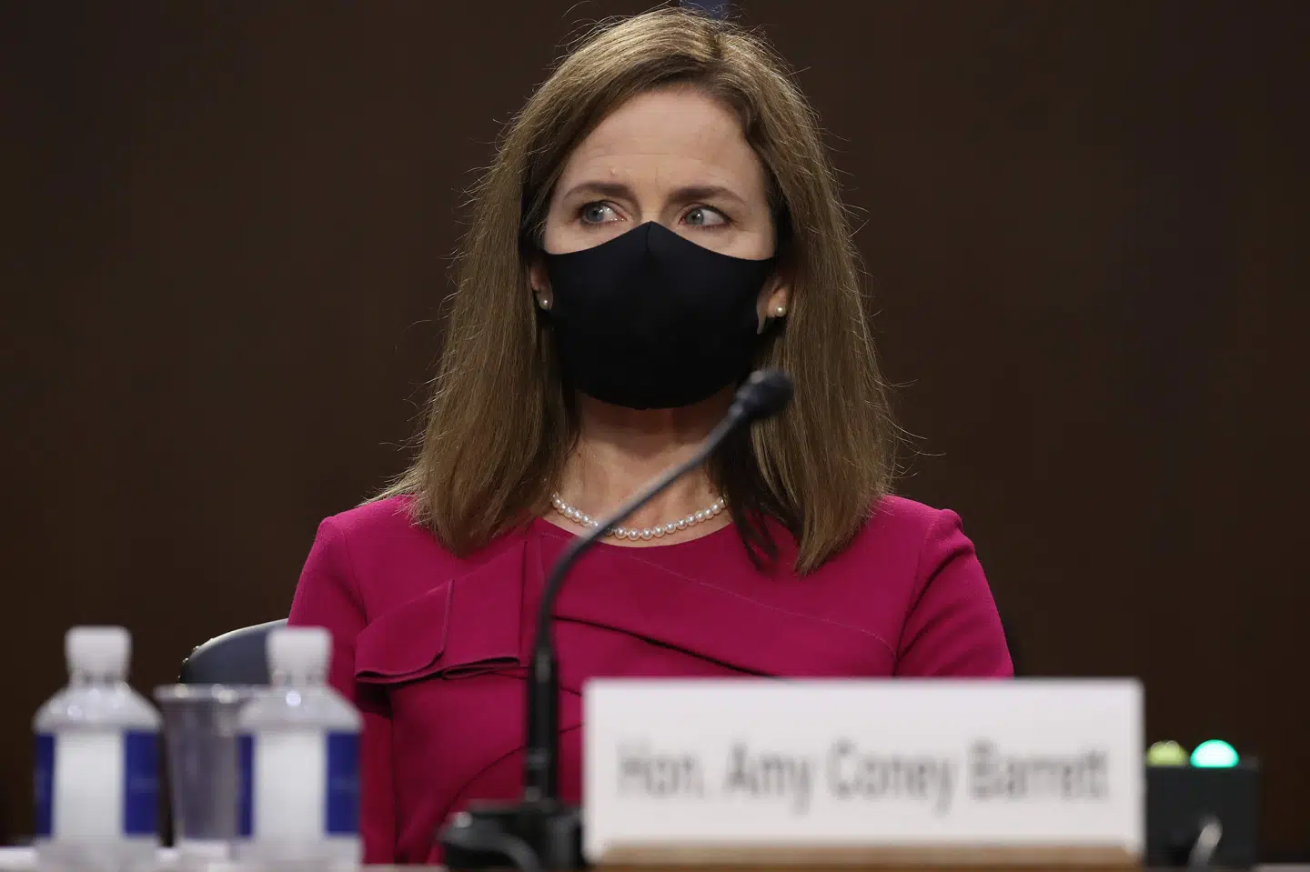 Iført mundbind har Amy Coney Barrett mandag indtaget pladsen i Senatet, hvor hun i denne uge skal høres, inden Senatet sidst på måneden stemmer om, hvorvidt hun skal udpeges som højesteretsdommer. Win Mcnamee/Ritzau Scanpix