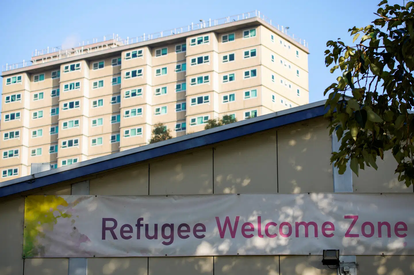 Et skilt med skriften flygtninge er velkomne ses uden for en boligblok i byen Melbourne i juli. Australiens regering bliver onsdag kritiseret for at sænke antallet af flygtninge, der får lov at komme ind i landet, de kommede år. Stringer/Reuters