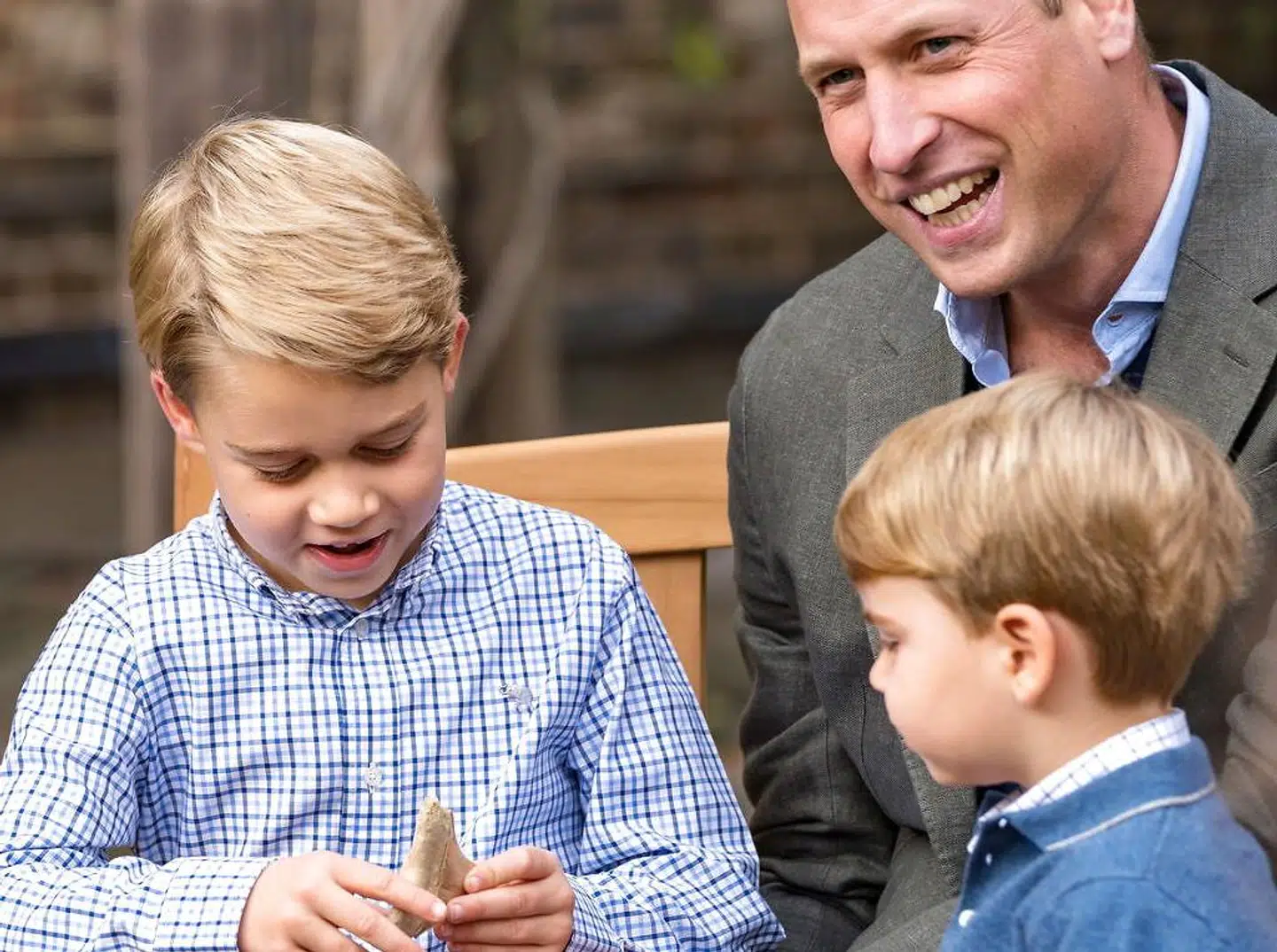 Storbritanniens prins William ser på, mens prins George viser hajtanden fra for sin lillebror prins Louis.