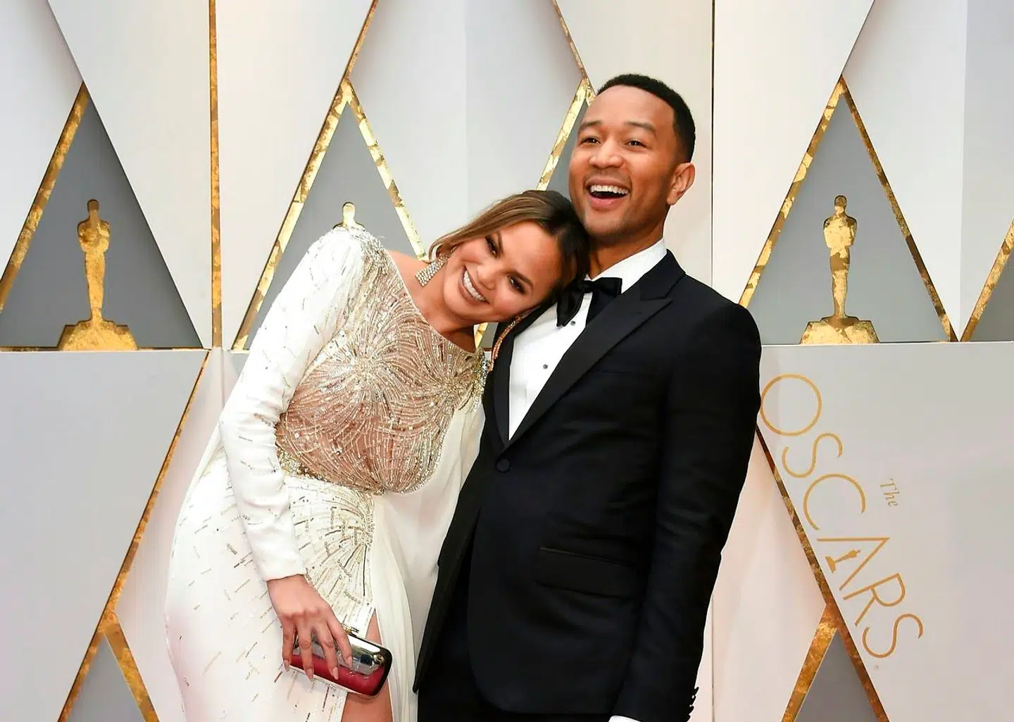 TOPSHOT - John Legend (R) and US model and wife of John Legend Chrissy Teigen arrive on the red carpet for the 89th Oscars on February 26, 2017 in Hollywood, California. / AFP PHOTO / VALERIE MACON
