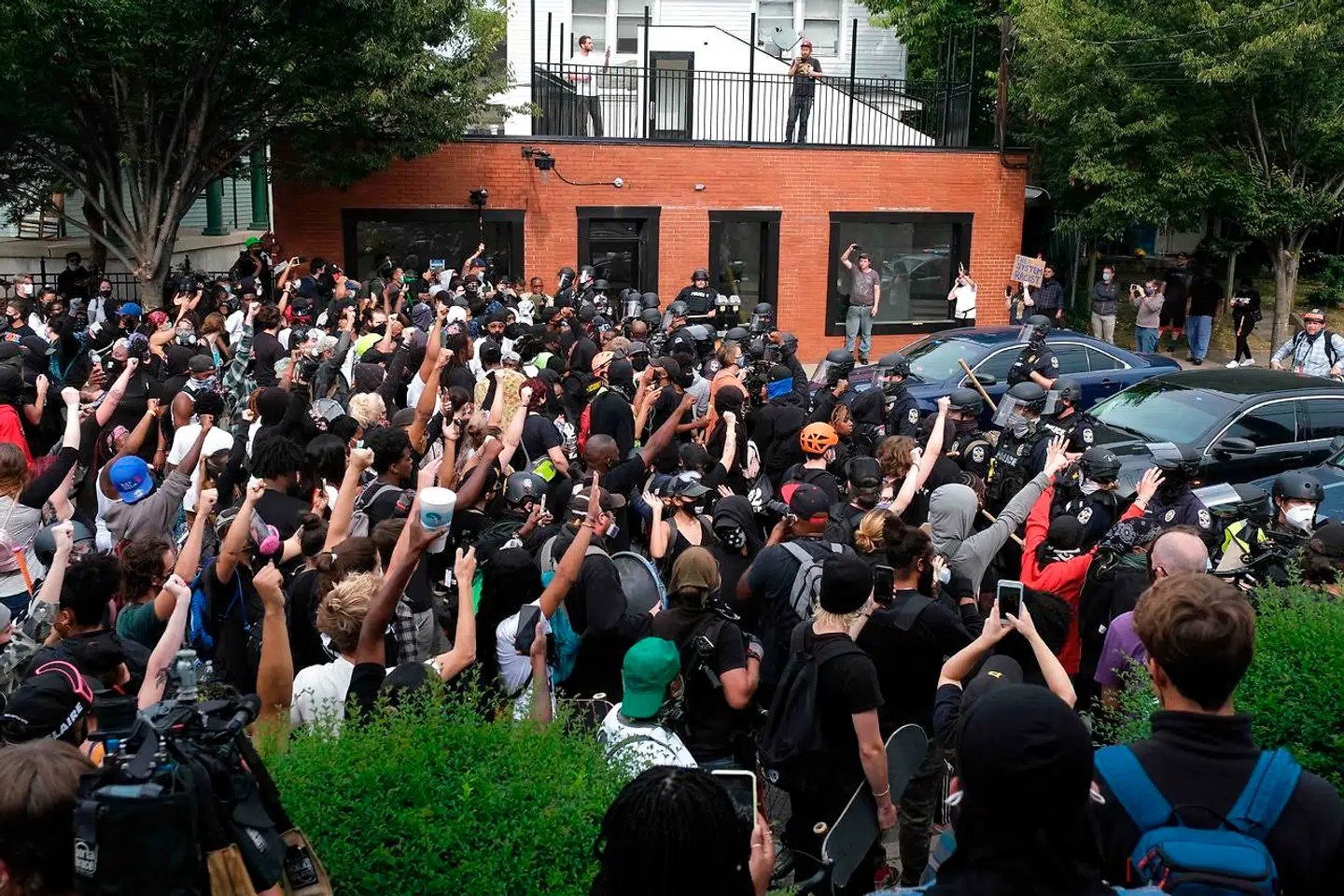 Kampklædt politi danner en mur foran demonstranterne,
