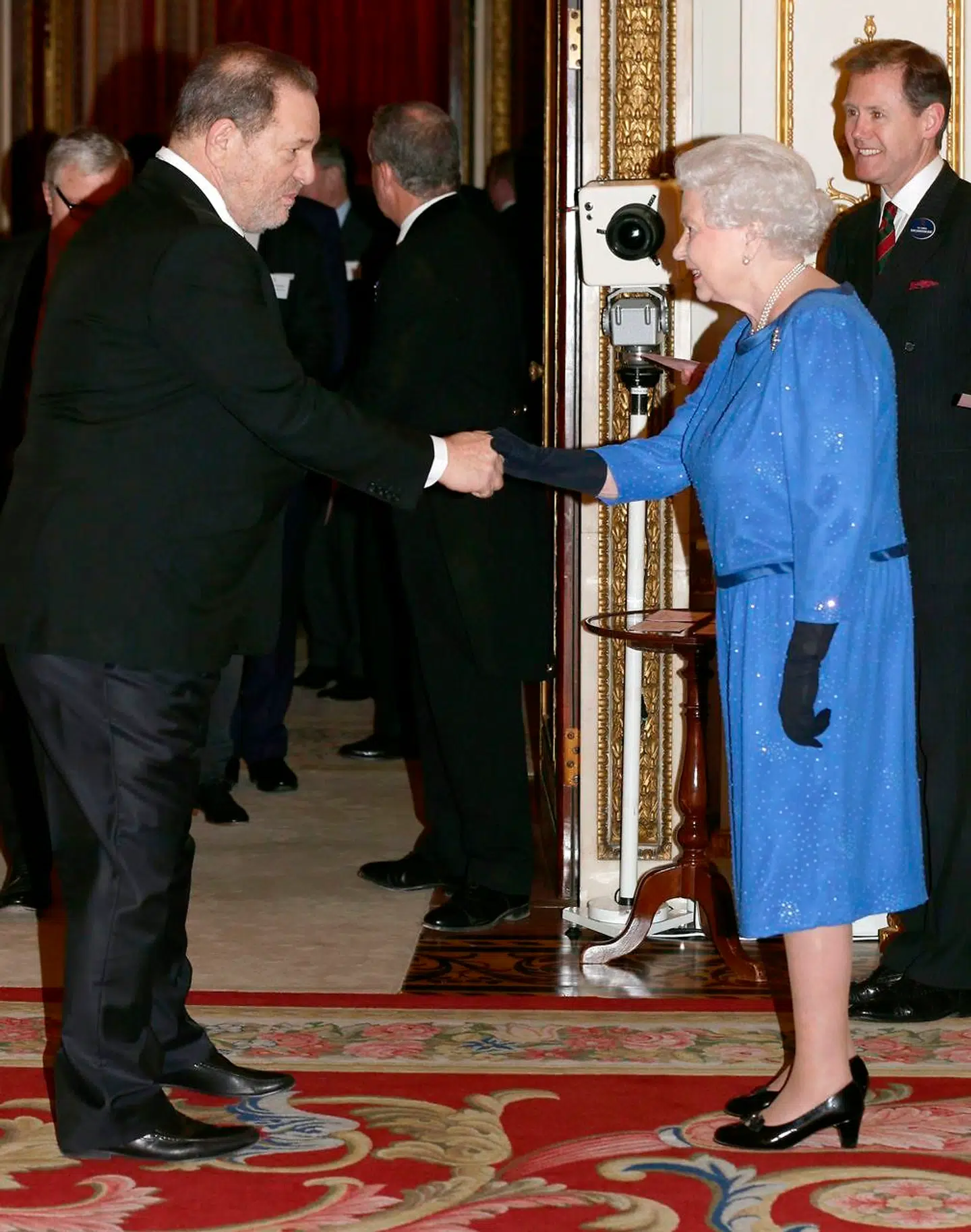 Dronning Elizabeth hilser på Harvey Weinstein under en resception i Buckingham Palace i 2014. Nu er den voldtægtsdømte filmproducer persona non grata i det britiske kongehus.