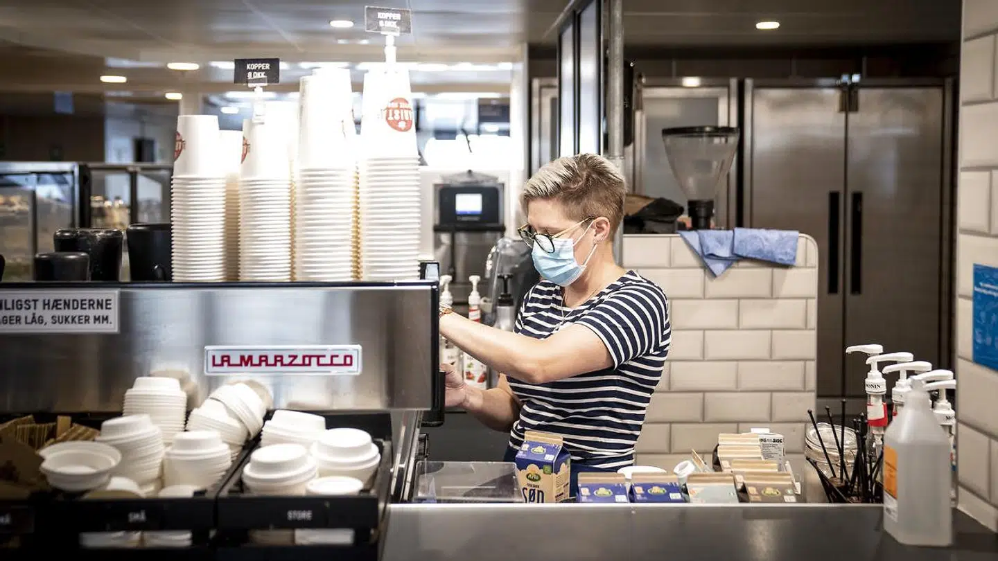 Fra og med torsdag den 17. september skal både gæster og ansatte bære mundbind på caféer, restauranter og barer. Kun hvis gæsterne er siddende ved et bord, må de tage mundbindet af. Her laver en ansat kaffe om bord på Molslinjen mellem Sjællands Odde og Aarhus.