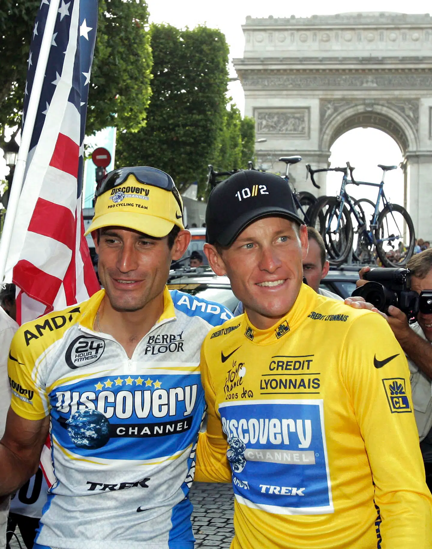 Discovery Channel team rider Lance Armstrong of the U.S. (R) and team mate George Hincapie pose for supporters in Paris after Armstrong won his seventh straight Tour de France, July 24, 2005. George Hincapie, one of Lance Armstrong's former team mates and closest allies, has admitted to using performance-enhancing drugs. The 39-year-old American, who rode alongside Armstrong in each of his seven Tour de France wins, released a statement on Wednesday confessing that he cheated. Picture taken July 24, 2005. REUTERS/Philippe Wojazer/Files (FRANCE - Tags: SPORT CYCLING DRUGS SOCIETY)