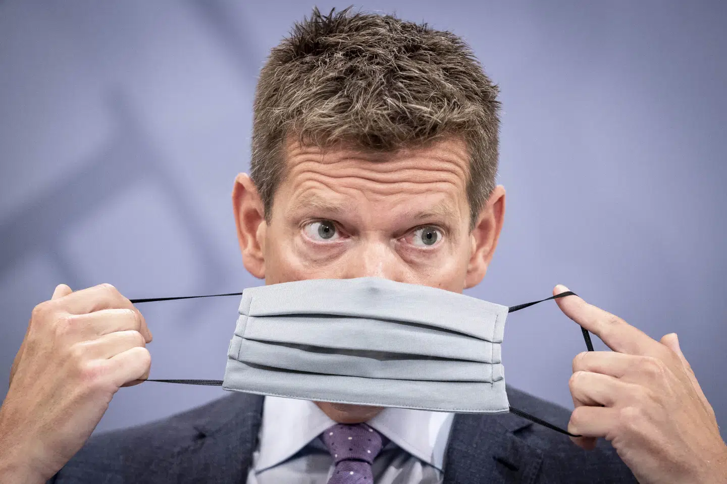 Sundhedsstyrelsens direktør, Søren Brostrøm, demonstrerer, hvordan man tager mundbind på, under pressemøde 15. august, hvor det bliver meddelt, at mundbind påbydes i offentlig transport fra 22. august. (Arkivfoto). Mads Claus Rasmussen/Ritzau Scanpix