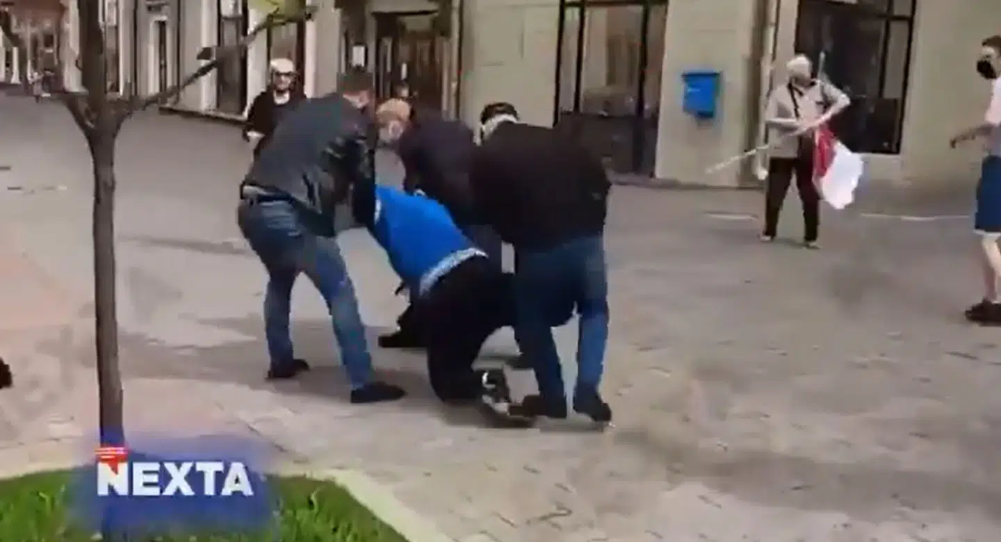 En demonstrant bæres væk af undercover politi i Minsk. Kort efter kommer meddemonstranter til og hjælper.