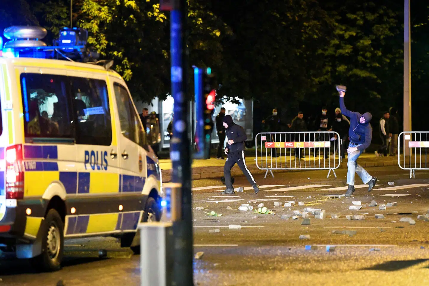 En demonstrant kaster en sten mod politiet i Rosengård 28. august 2020.