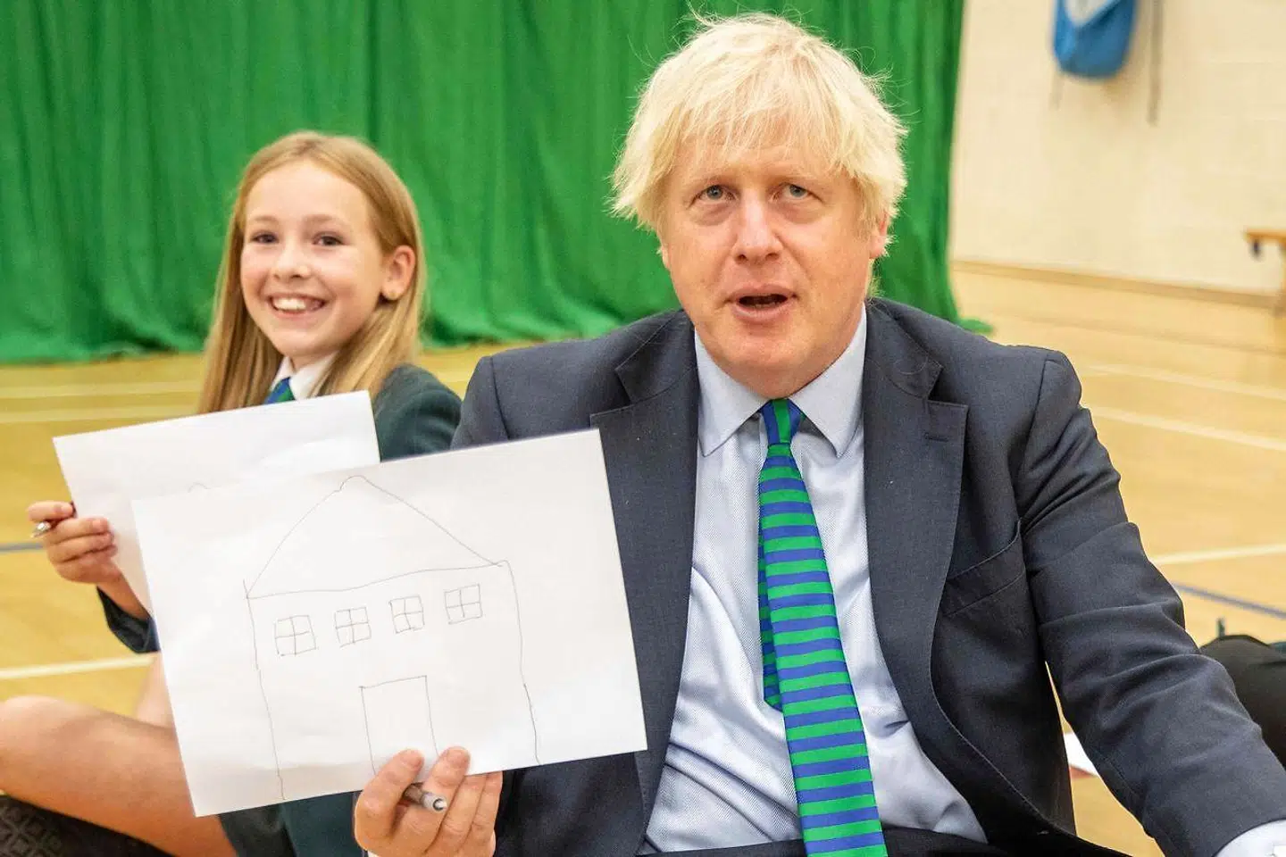 Boris Johnson fremviser en tegning under sit besøg på Castle Rock School.