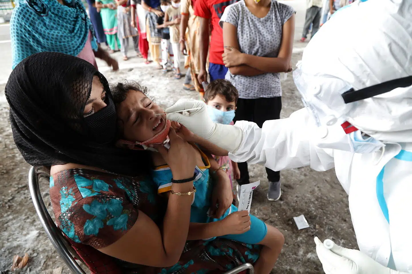 En sundhedsmedarbejder tager en corona-prøve fra et barn i Jammu, Indien, 25. august. 2020. EPA.