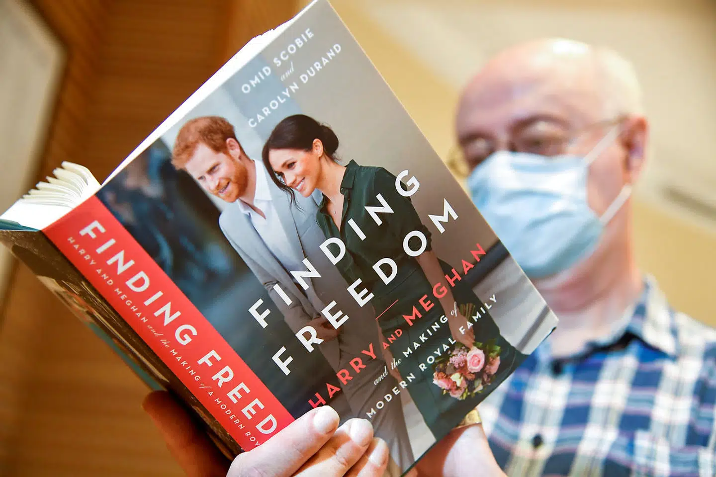 An employee holds a copy of 'Finding Freedom', an unofficial biography on Prince Harry and Meghan Markle, the Duke and Duchess of Sussex, at a Waterstones bookshop in London, Britain August 12, 2020. REUTERS/Toby Melville