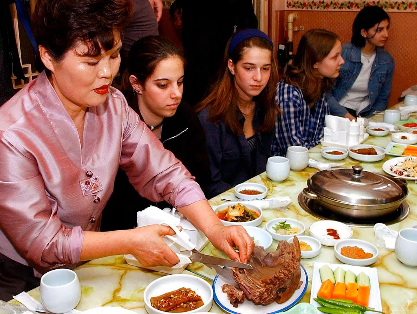 En sydkoreansk kvinde skærer hundekød op for studerende i en af de fineste restauranter i Seoul på dette arkivfoto fra 2002.