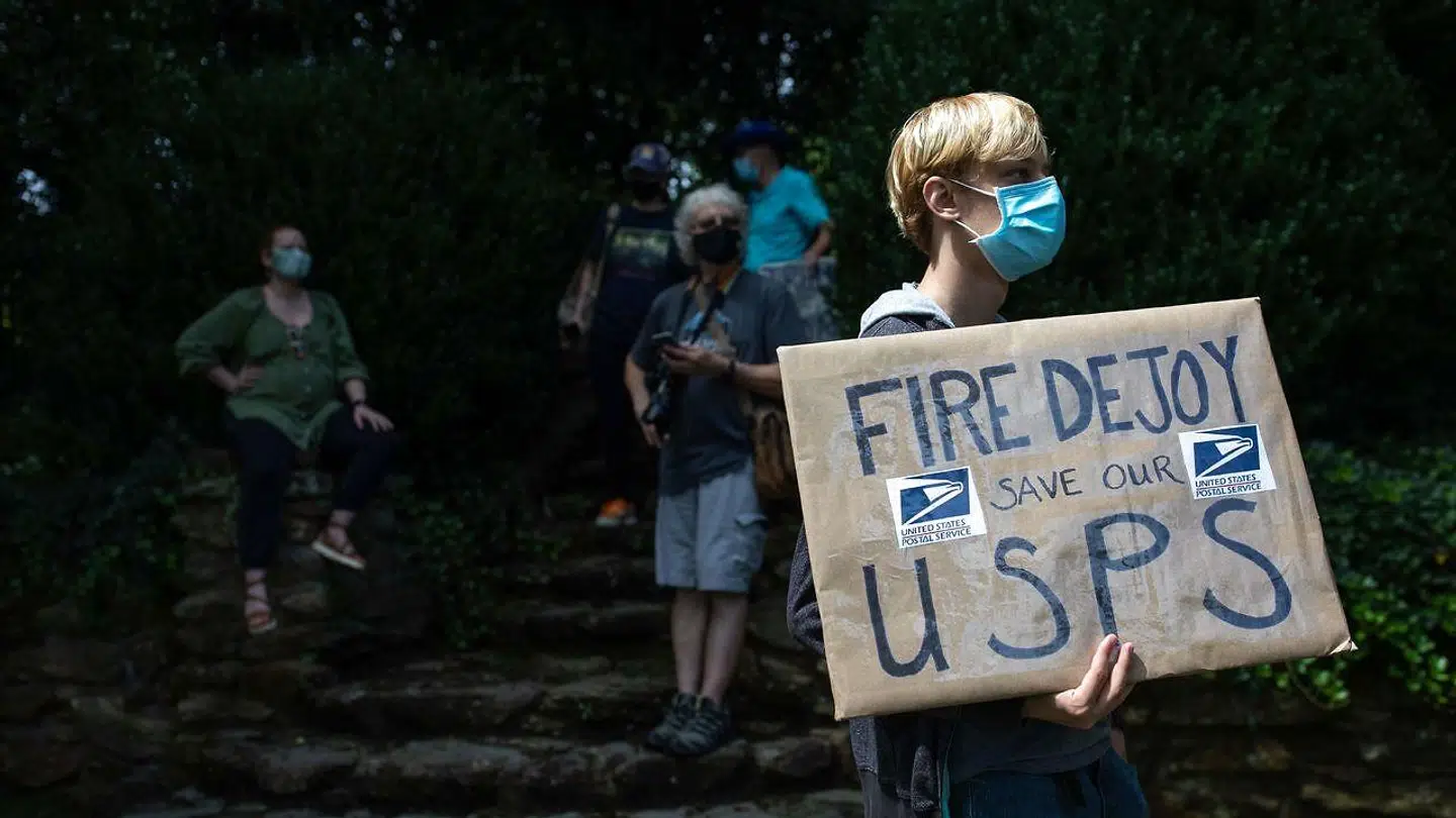 En demonstrant er gået på gaden med et budskab om at redde US Postal Service.