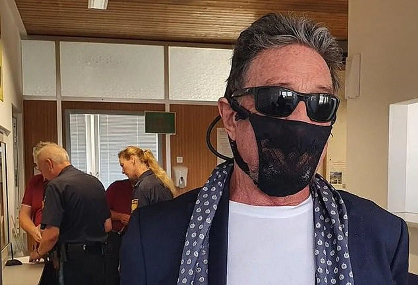 John McAfee i tolden i Oslo med et særpræget 'mundbind'.