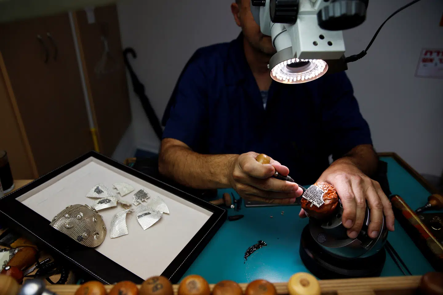 En medarbejder arbejder på en del af det gyldne mundbind. Mundbindet bliver produceret på Yvels smykkefabrik i bydelen Motza lidt uden for Jerusalem. Ronen Zvulun/Reuters