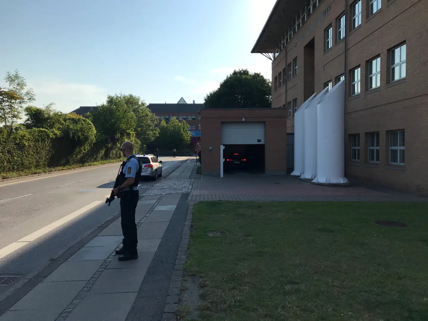 Massiv sikkerhed ved retten. De tiltalte bliver kørt ind i garagen til højre. Foto: Birger Andersen