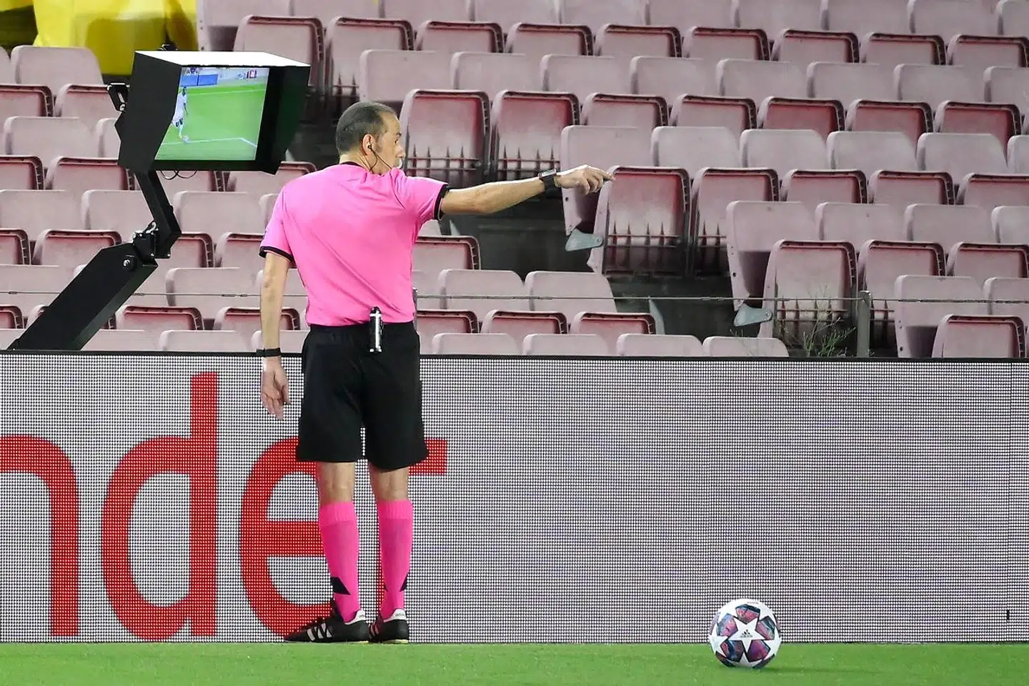 Turkish referee Cuneyt Cakir VAR replay on the fault made on Barcelona's Argentine forward Lionel Messi during the UEFA Champions League round of 16 second leg football match between FC Barcelona and Napoli at the Camp Nou stadium in Barcelona on August 8, 2020. (Photo by LLUIS GENE / AFP)