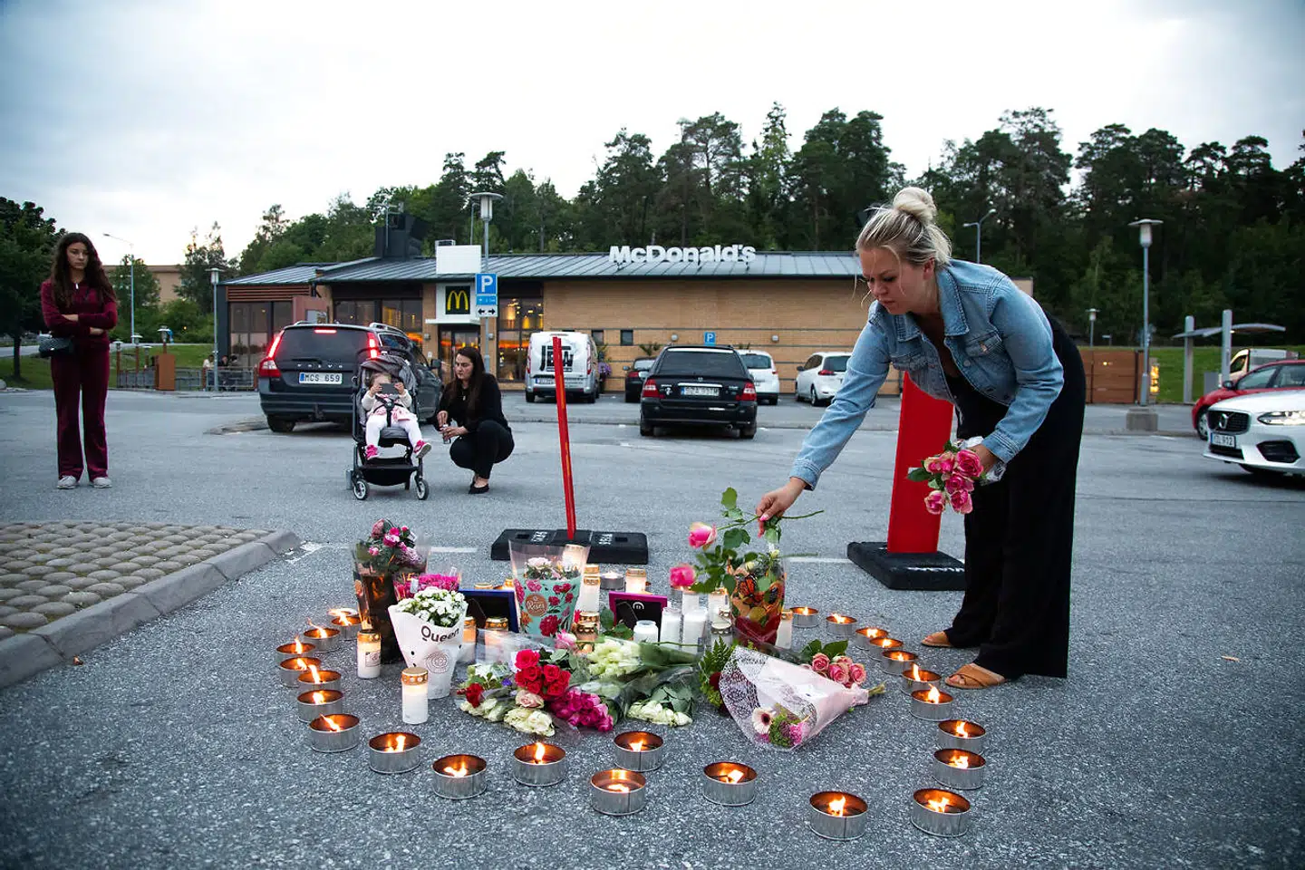 Blomster og lys på parkeringspladsen, hvor en 12-årig pige blev dræbt af skud.