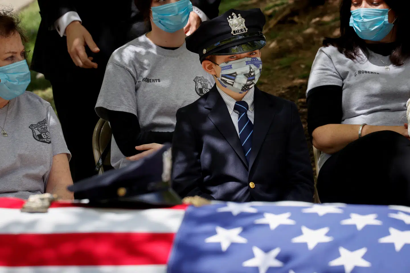 En dreng ser til mens hans far, der døde med coronavirus, bliver begravet i delstaten New Jersey. Mike Segar/Reuters