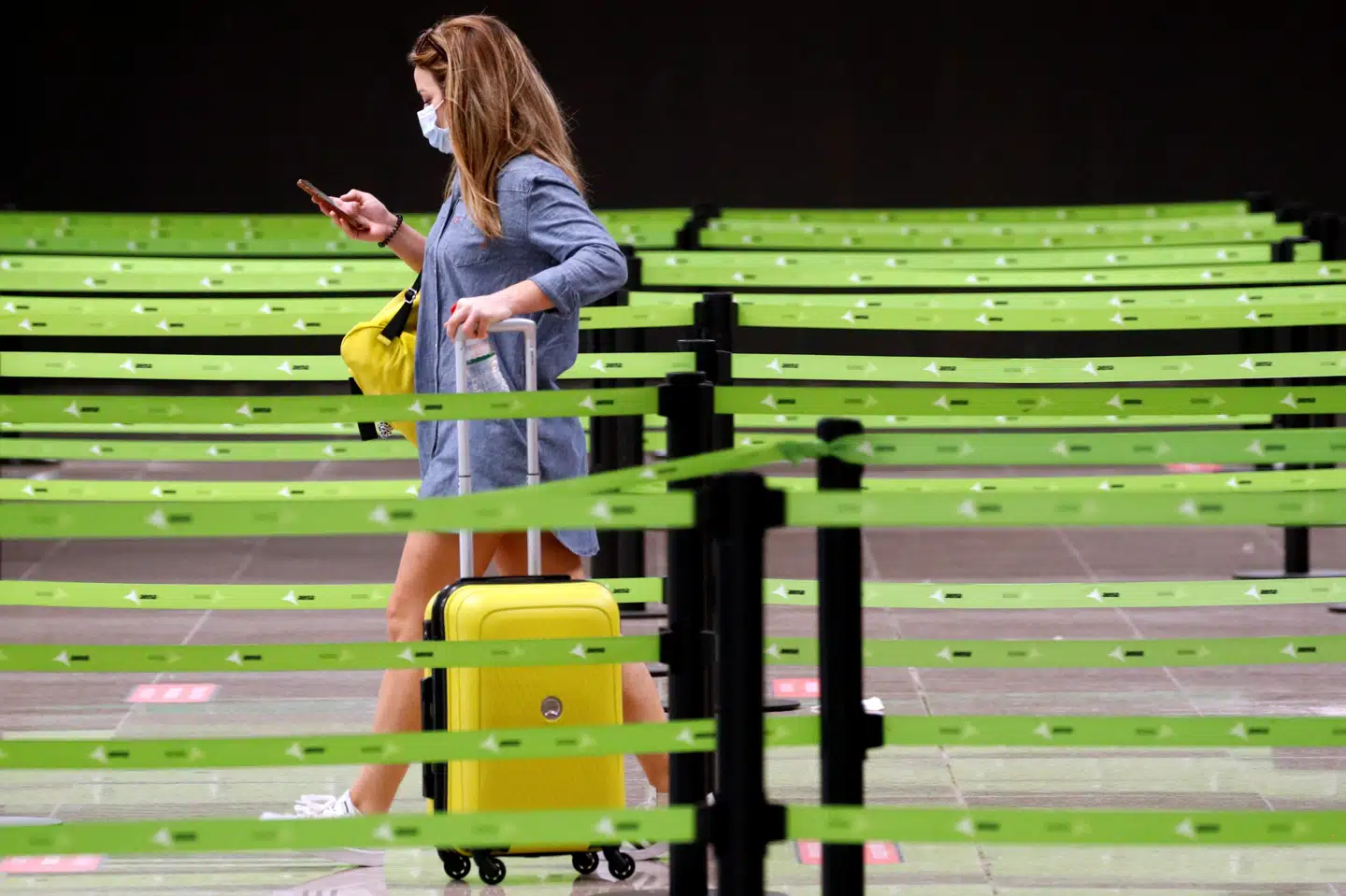 En passager i Ryanairs kø til check-in i lufthavnen i Barcelona søndag. Hvis rejsen går til Storbritannien, venter der 14 dages karantæne. Årsagen er en opblussen i tilfælde af smittede i Spanien med covid-19. Albert Gea/Reuters