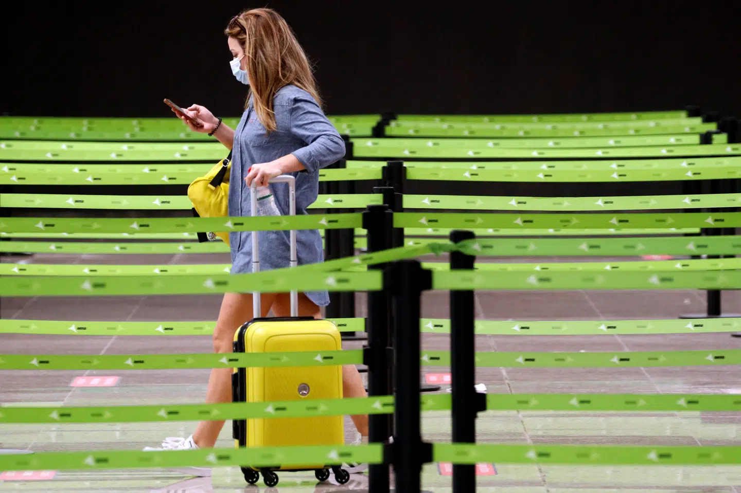 En passager i Ryanairs kø til check-in i lufthavnen i Barcelona søndag. Hvis rejsen går til Storbritannien, venter der 14 dages karantæne. Årsagen er en opblussen i tilfælde af smittede i Spanien med covid-19. Albert Gea/Reuters