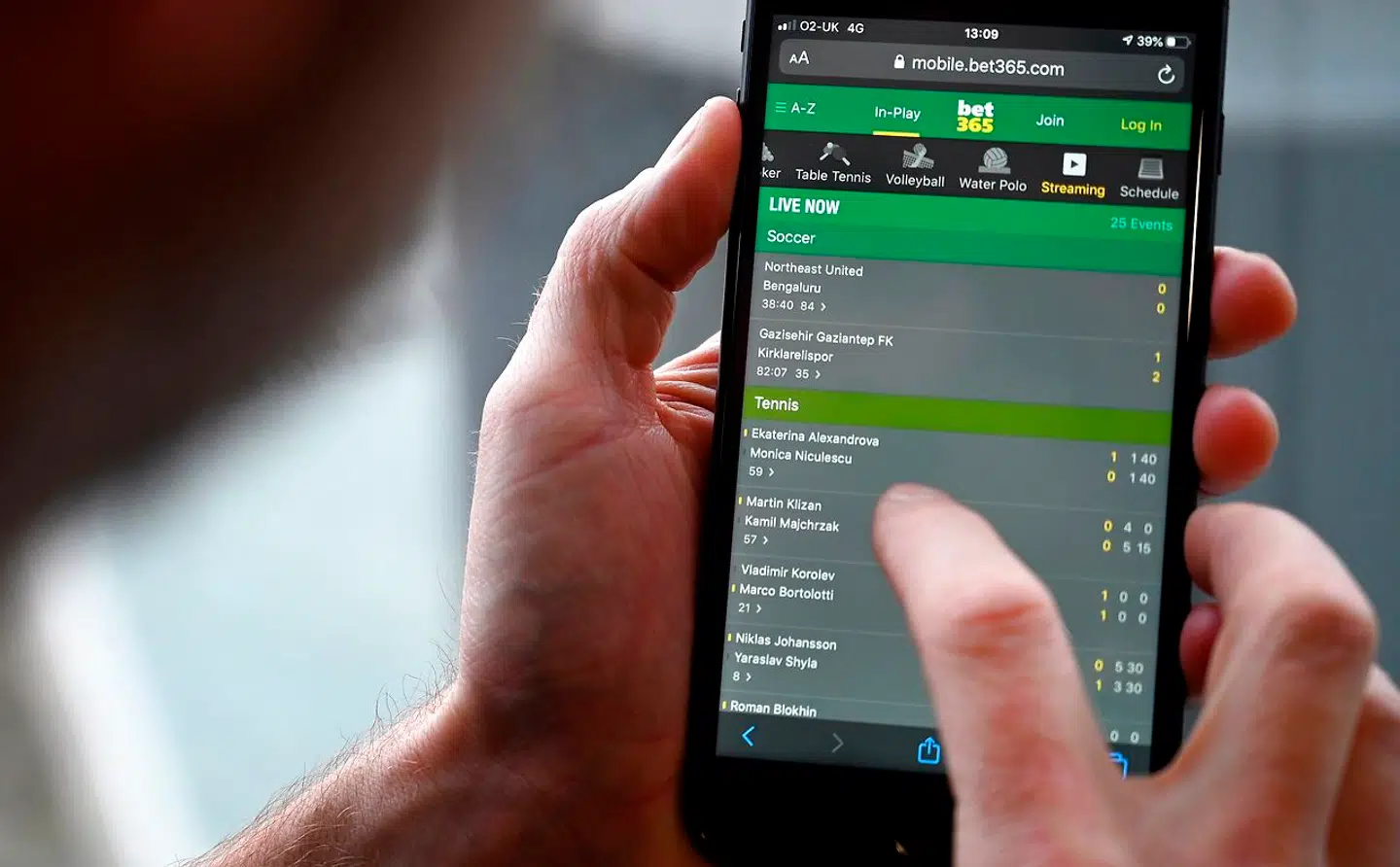 A man poses for a photograph with the online gambling website Bet365 displayed on a smartphone, in London on December 18, 2019. Denise Coates, chief executive of British online betting giant Bet365, has retained her place as Britain's highest-paid boss, according to the group's annual report published on Wednesday. She was paid a basic salary of £277 million ($366 million, 328 million euros) in the group's financial year to March, the company's annual report showed. Paul ELLIS / AFP