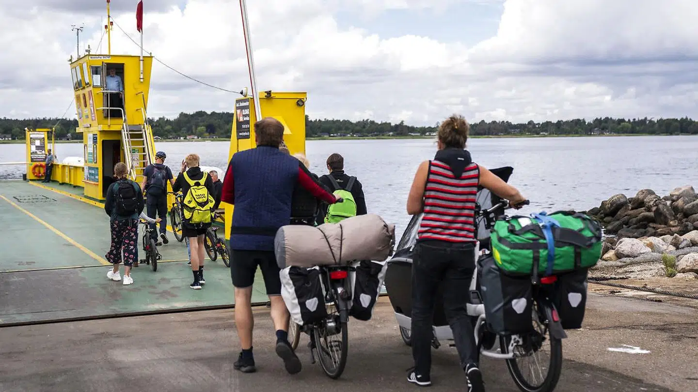 Passagerer på cykel eller gåben stiger om bord på Østre Færge til Orø ved Hammer Bakke.