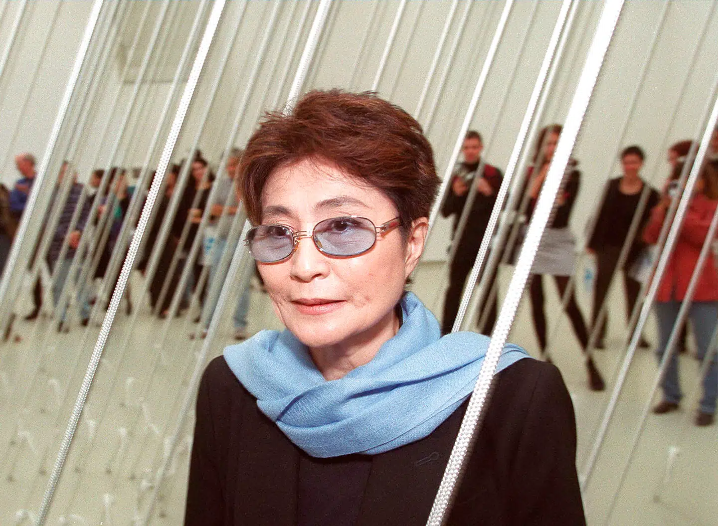 Artist Yoko Ono, widow of the late John Lennon, poses in front of one of her artworks from a retrospective show at the Israeli Museum in Jerusalem 25 November 1999. The exhibition, titled "Yoko Ono: Have You Seen the Horizon Lately", will be inaugurated November 26 to promote Ono's efforts to advance world peace and unity. Ono, 66, will also open another exhibition in Um el-Fahm, an Arab town in central Israel.