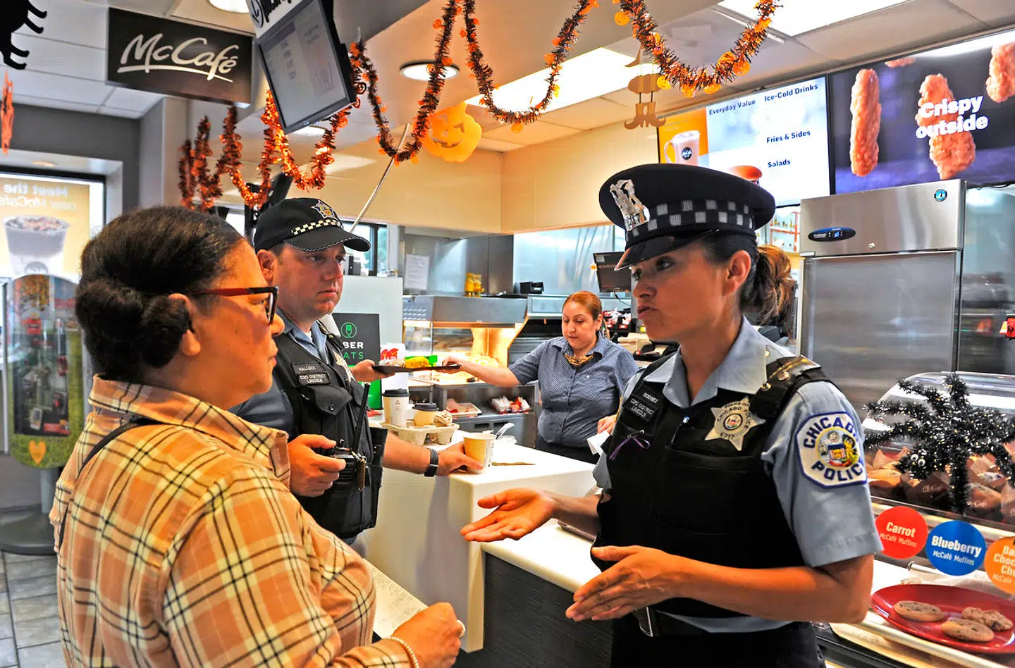 En politibetjent i samtale med en ansat i en McDonald's-restaurant i USA. (Arkivfoto)