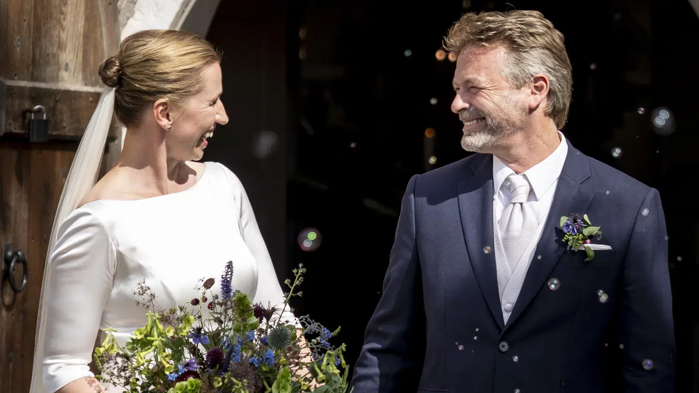 Det smilende brudepar foran kirken efter vielse.