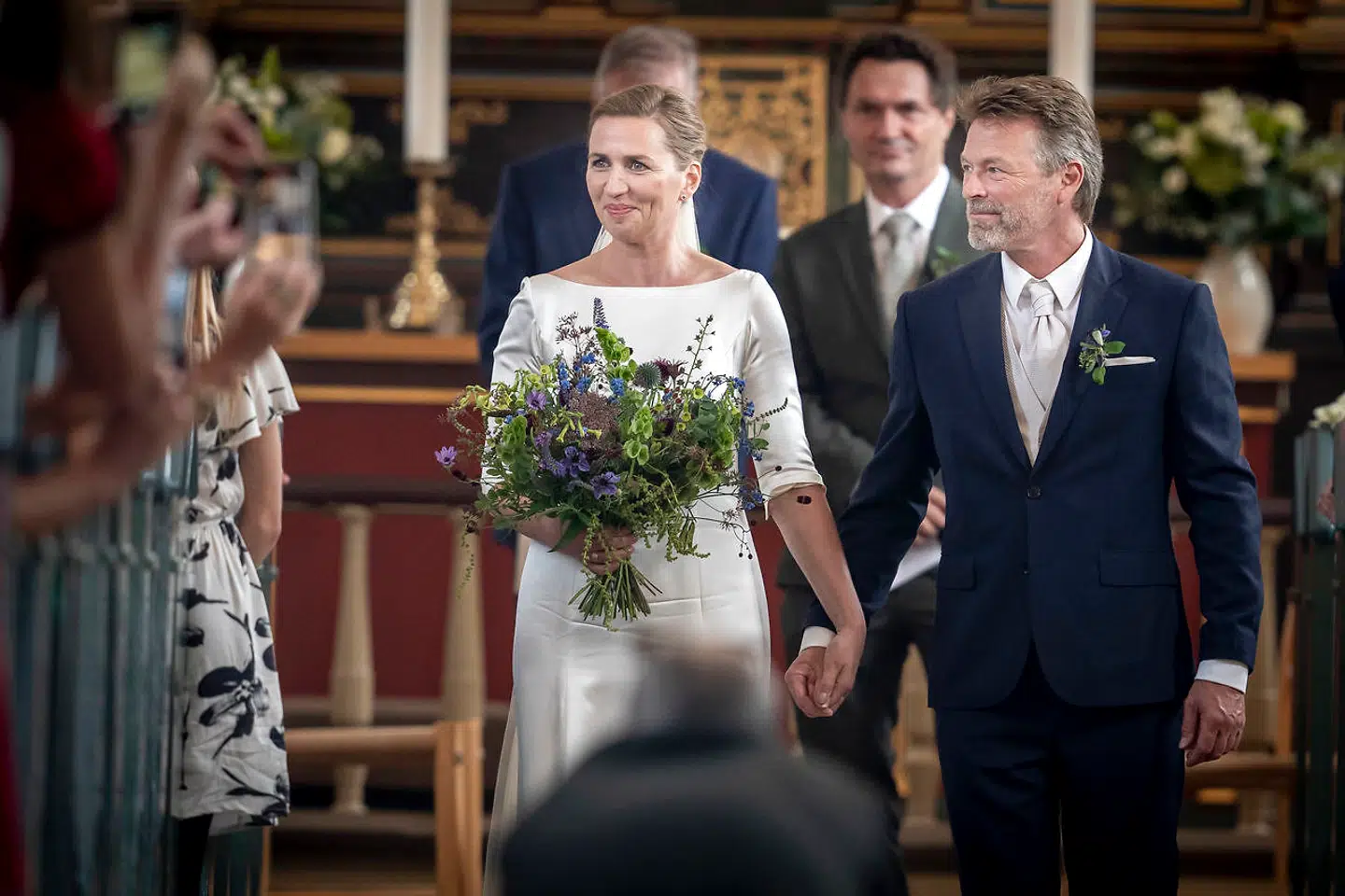 Brudeparret på ved ud af kirken efter vielsen mellem Statsminister Mette Frederiksen og filmfotograf Bo Tengberg i Magleby Kirke på Sjælland, onsdag den 15. Juli 2020. Mette Frederiksen og Bo Tengberg blev gift onsdag eftermiddag.De har officielt dannet par siden 2014 og har været forlovet siden 2017. Brylluppet har af flere omgange været udskudt. (Foto: Mads Claus Rasmussen/Ritzau Scanpix)