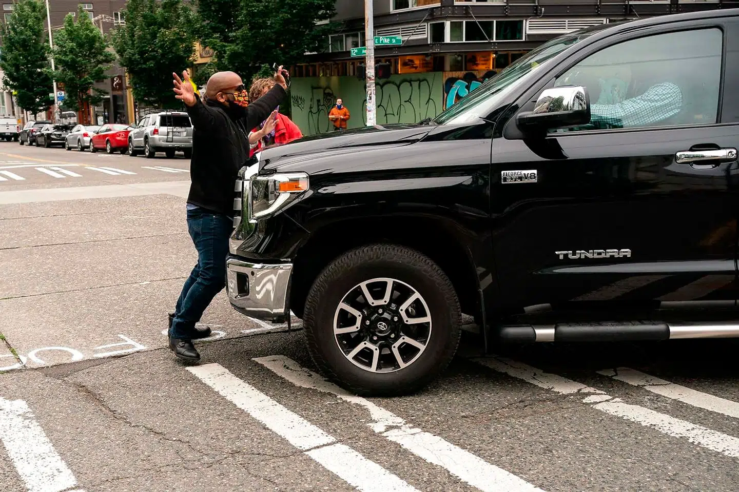 En mand, Derrick Drungo, stopper en bil, der bruges af et lokalt tvhold.