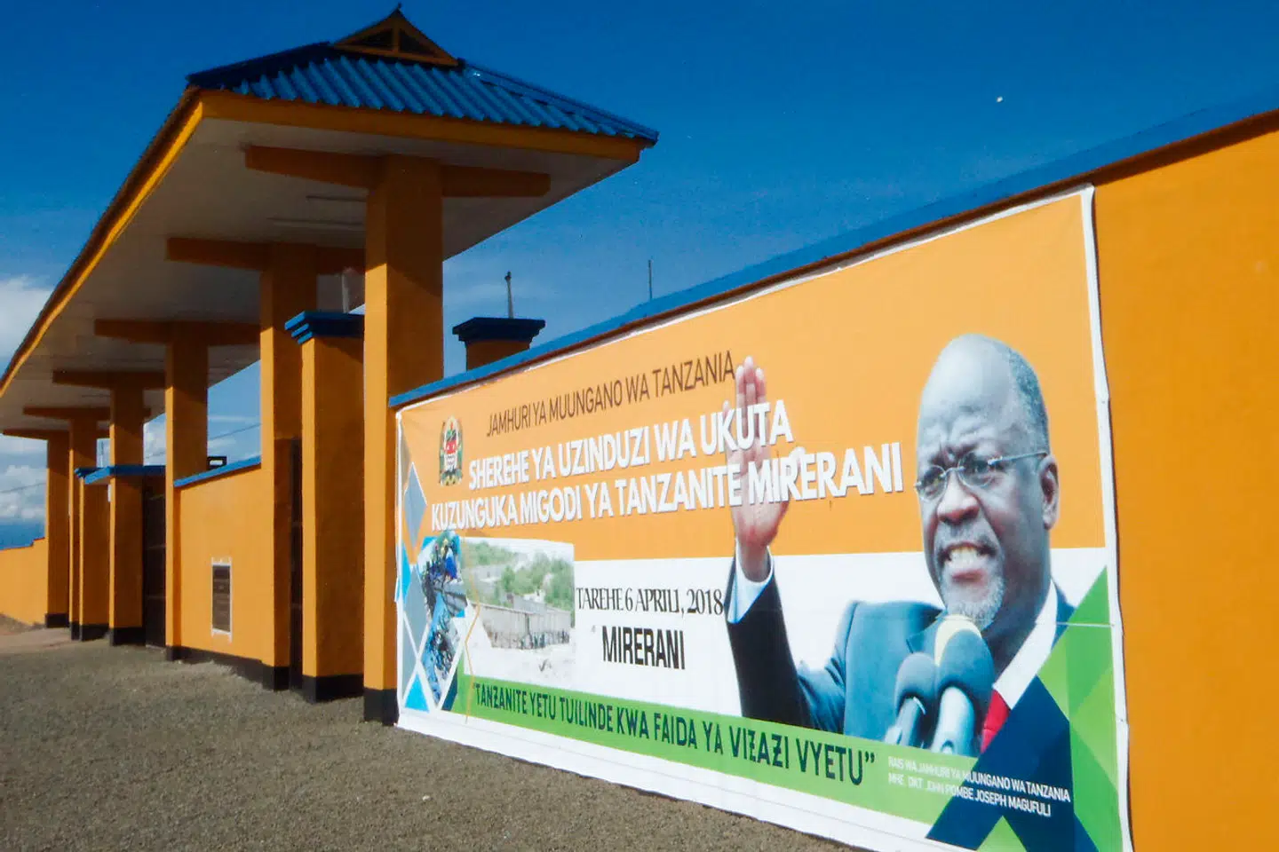 Et banner med præsident John Joseph Magufuli er sat op på væggen af det 24 km lange hegn omkring Melani, der skal stoppe smugleriet af Tanzanite.