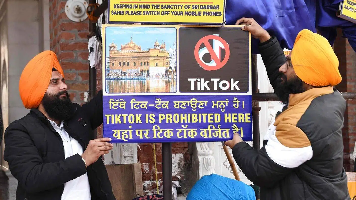 To sikher ved det Gyldne Tempel i Amritsar i det nordlige Indien hænger et skilt op, hvor det fremgår, at TikTok ikke må benyttes på stedet.