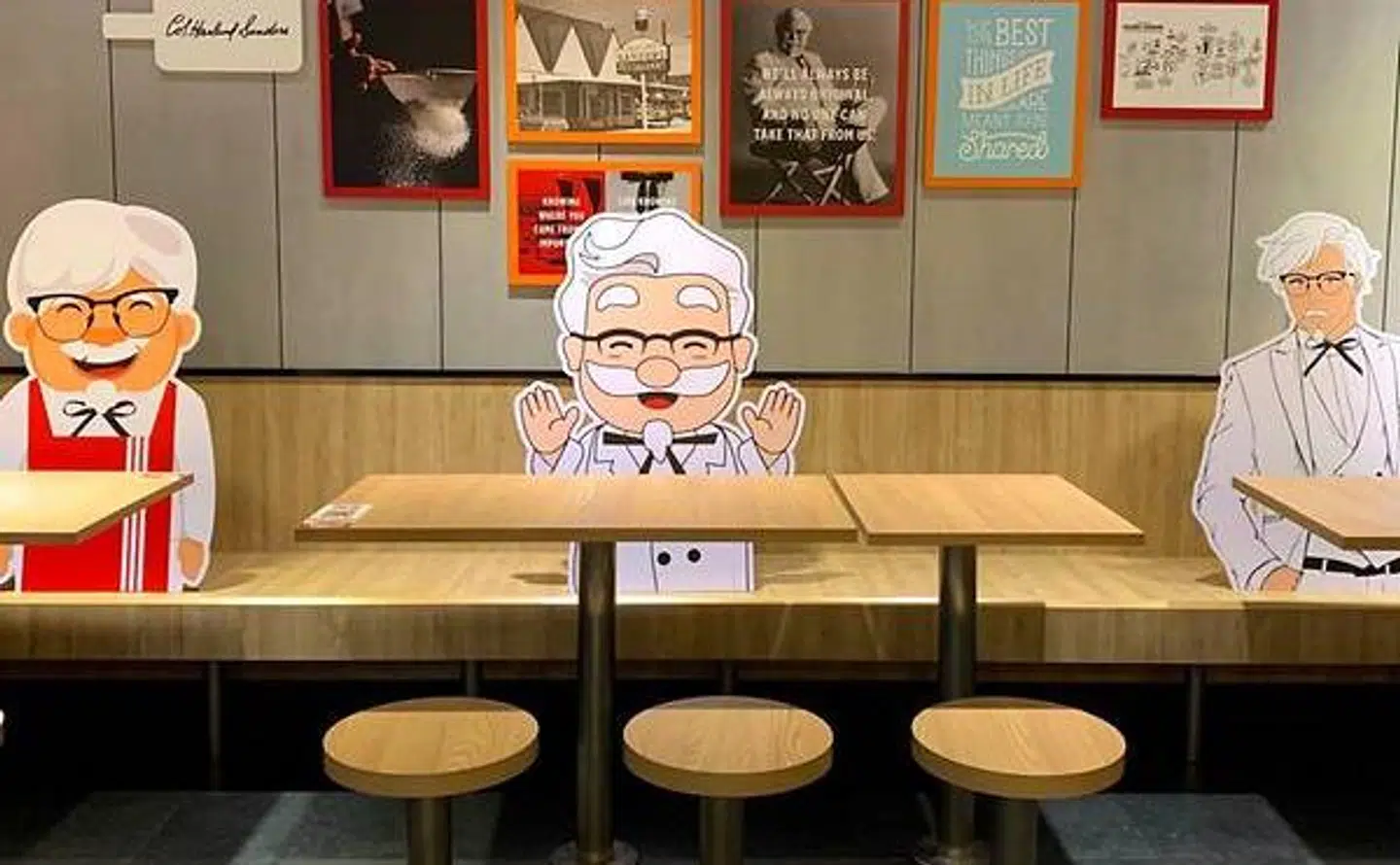Papfigurer af Kentucky Fried Chickens grundlægger, obert Sanders, står imellem de spisende på restauranterne i Singapore.