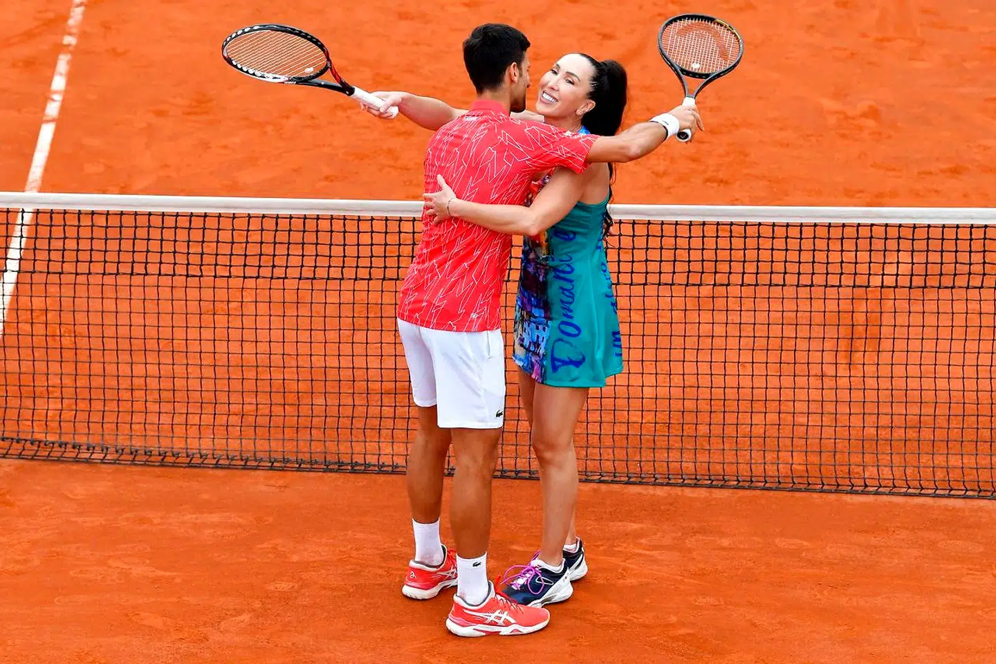 (FILES) In this file photo taken on June 12, 2020 Serbia's Novak Djokovic hugs Jelena Jankovic during a tennis doubles against Serbia's Nenad Zimonjic and Olga Danilovic during a charity exhibition hosted by Novak Djokovic, in Belgrade. - Novak Djokovic has also tested positive for coronavirus on June 23, 2020 along with Grigor Dimitrov, Borna Coric and Viktor Troicki, after taking part in an exhibition tennis tournament in the Balkans featuring world number one Novak Djokovic, raising questions over the sport's planned return in August. (Photo by Andrej ISAKOVIC / AFP)