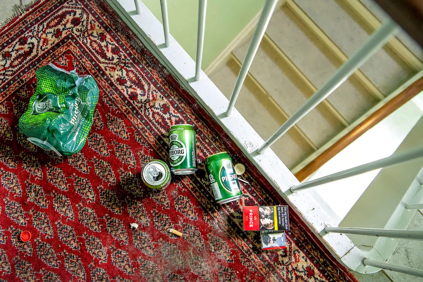 Kvinden i opgangen har affald og tøj liggende flere steder på trapperne. Lugten fra hendes lejlighed kan mærkes på gangen.