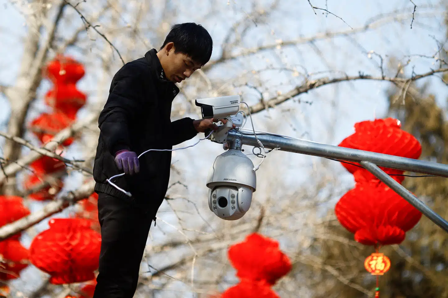 Overvågningsudstyr fra det kinesiske selskab Hikvision - som her sættes op af en medarbejder i Ditan Park i Beijing - er blevet købt af flere danske offentlige institutioner, selv om de ifølge den amerikanske regering bruges til undertrykkelse i Kina. (Arkivfoto) Thomas Peter/Reuters