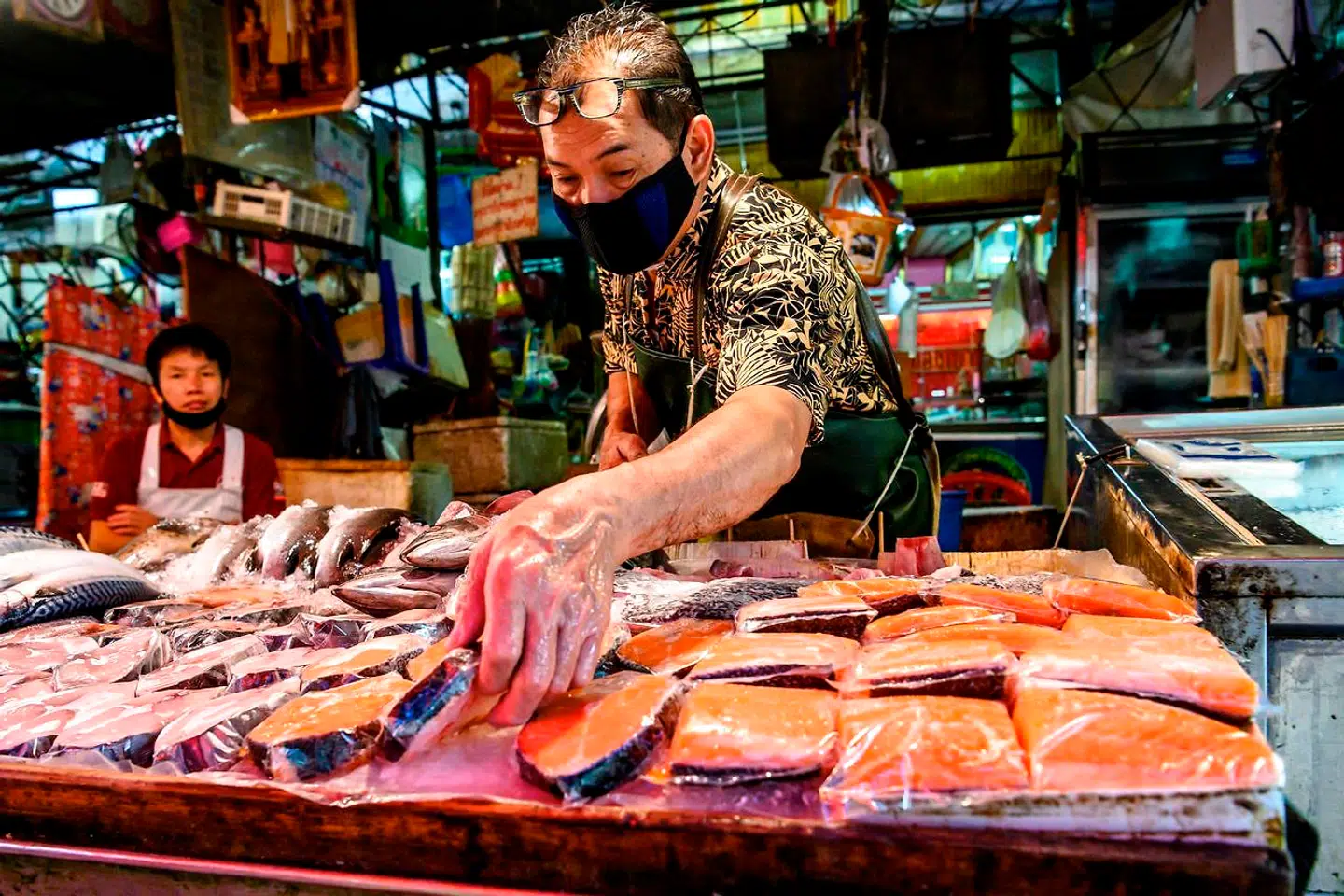 En sælger viser sine laks frem på Khlong Toei Market i Bangkok.